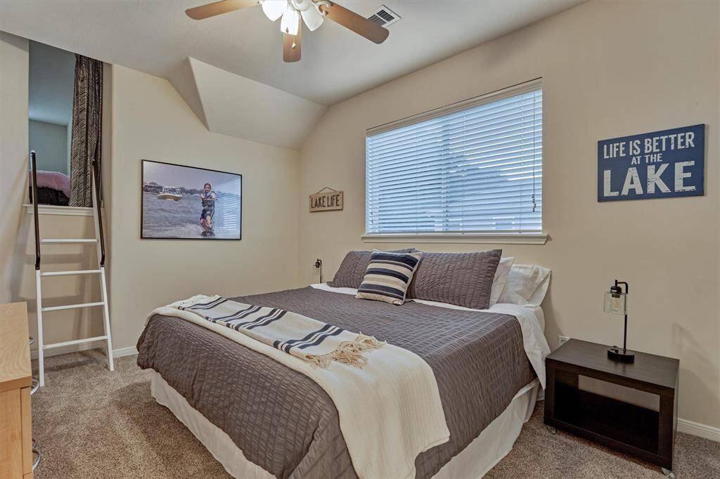 The first guest bedroom upstairs features a walk-in closet and a fun, unique loft area.