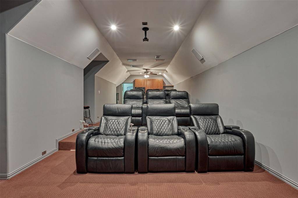 A view from the back of the theater room towards the built-in kitchenette, perfect for preparing snacks and drinks during movie nights or game days.