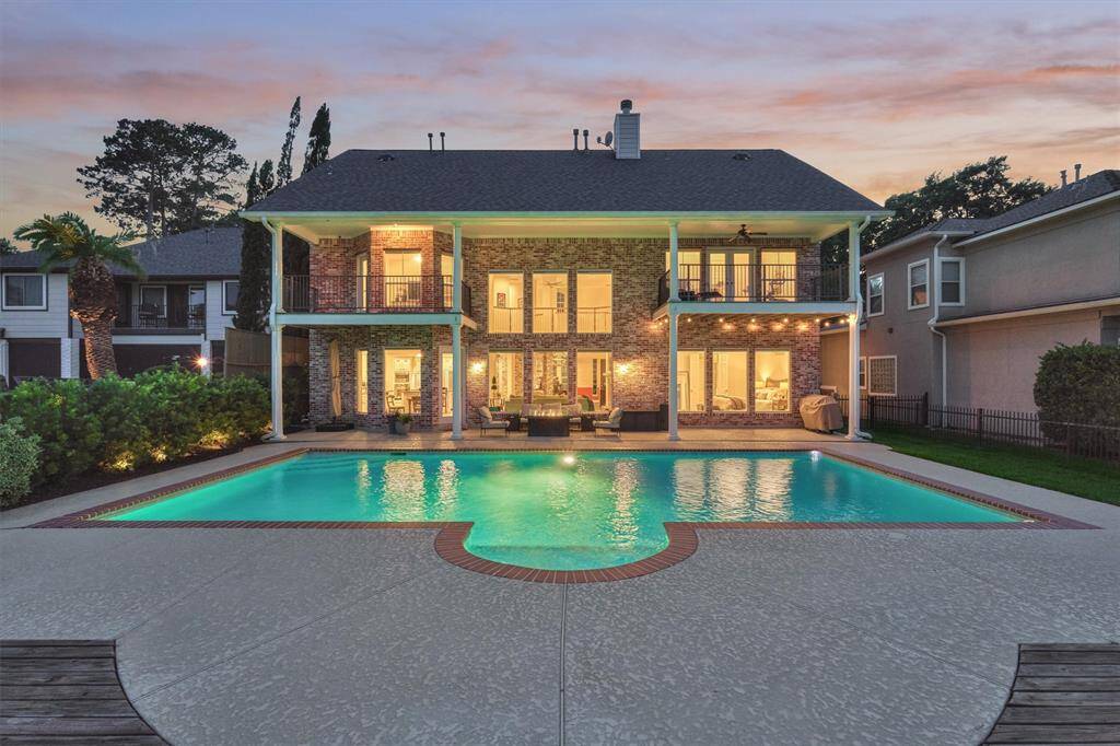 The home and pool are beautifully illuminated at night, creating a warm and inviting ambiance.
