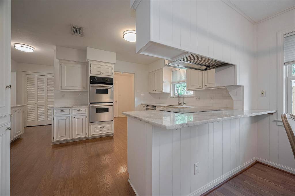 Lovely updated kitchen with light counter tops and backsplash.  You can enjoy views of the backyard from the kitchen.
