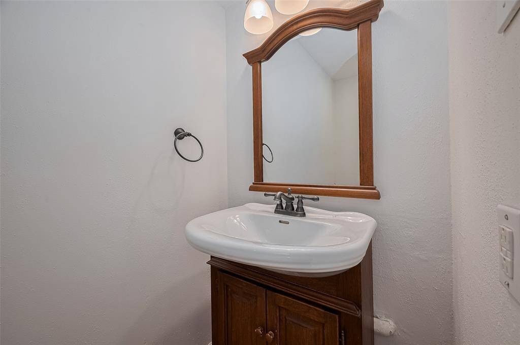 The half bath is located near the laundry room and garage entry.