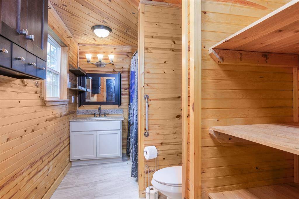 En suite bath has a stand up shower and storage for linens and toiletries