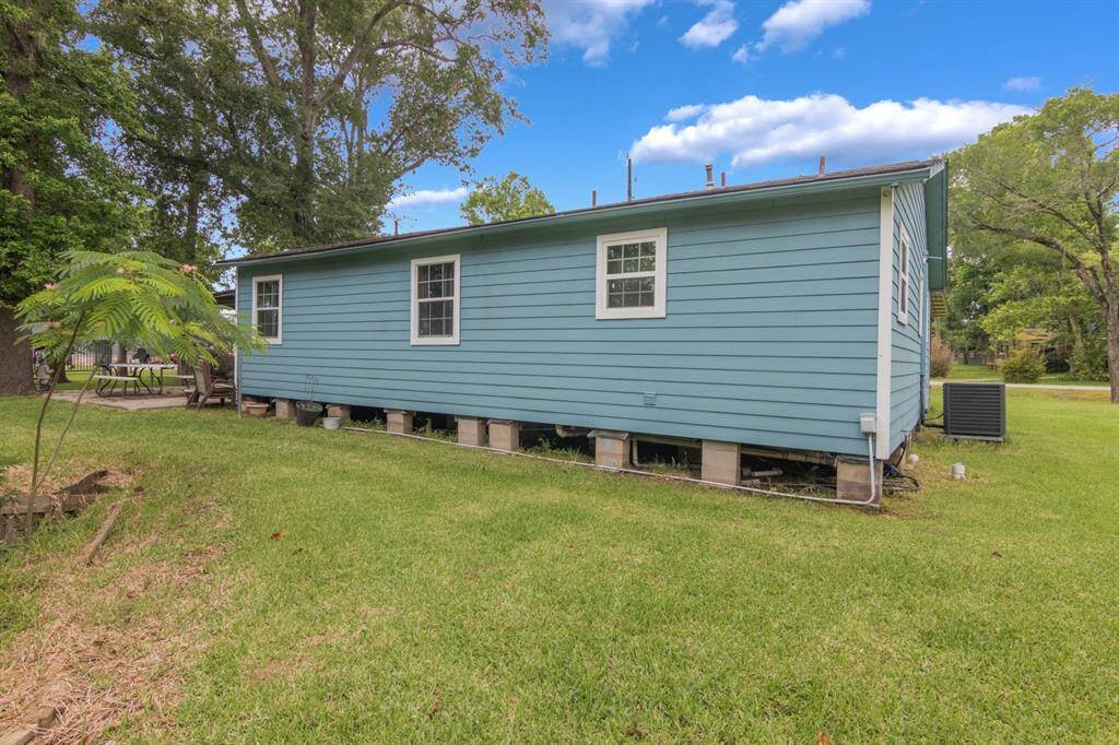 View of the side of the home, showing newer HVAC and a great picnic table area to enjoy your catch of the day