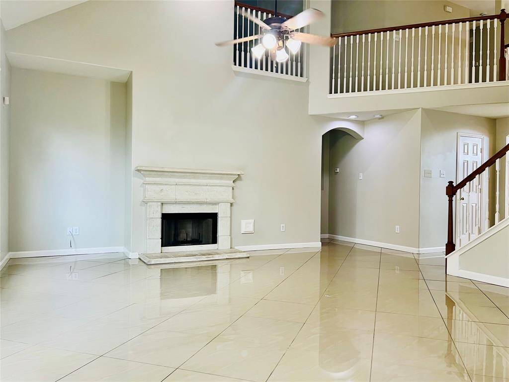 Spacious family room offers a gas log fireplace &  high ceiling.