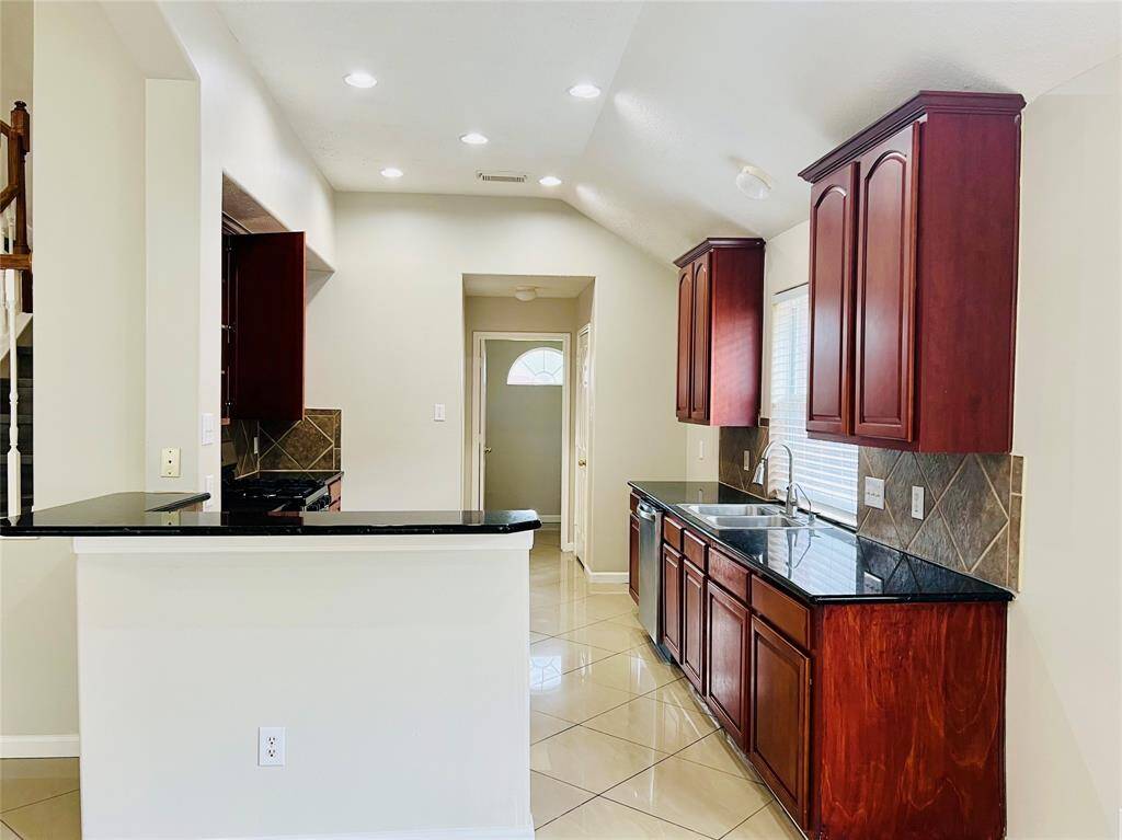 This amazing kitchen features granite countertops, tile backsplash, NEW stainless steel appliances and a gas cooktop.