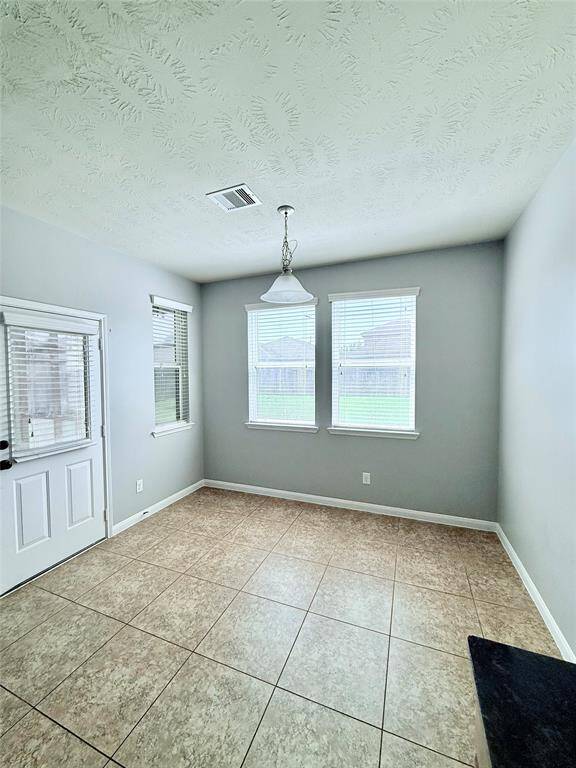 Bright and inviting breakfast room with large windows offering a view of the backyard, perfect for enjoying morning coffee.