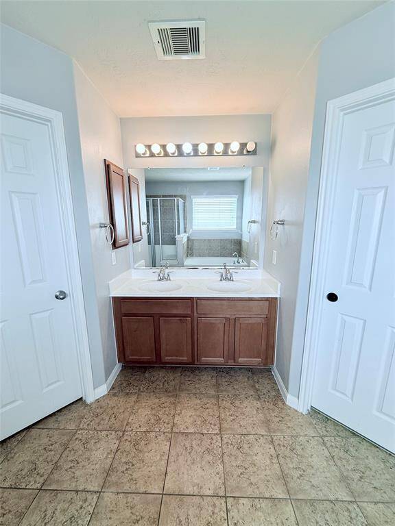 Experience luxury in the primary bath, featuring a dual-sink vanity and a spacious layout for ultimate relaxation.