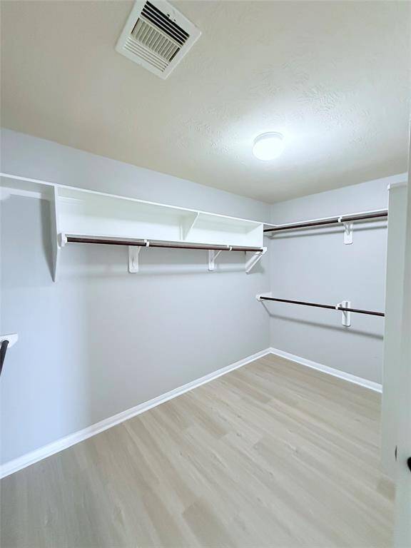 Expansive primary closet with ample shelving and hanging space, perfect for organizing your wardrobe.
