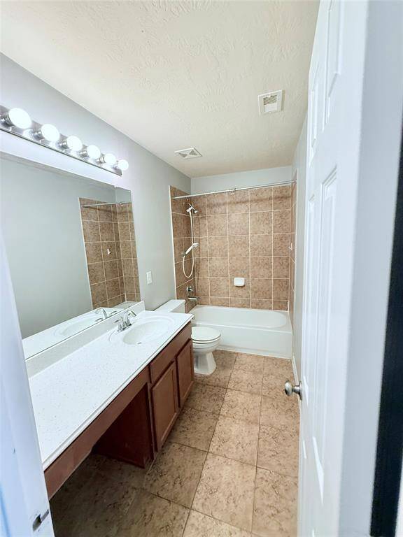 Modern second bathroom featuring a spacious vanity, elegant tile flooring, and a shower-tub combination. Ideal for guests or family convenience.