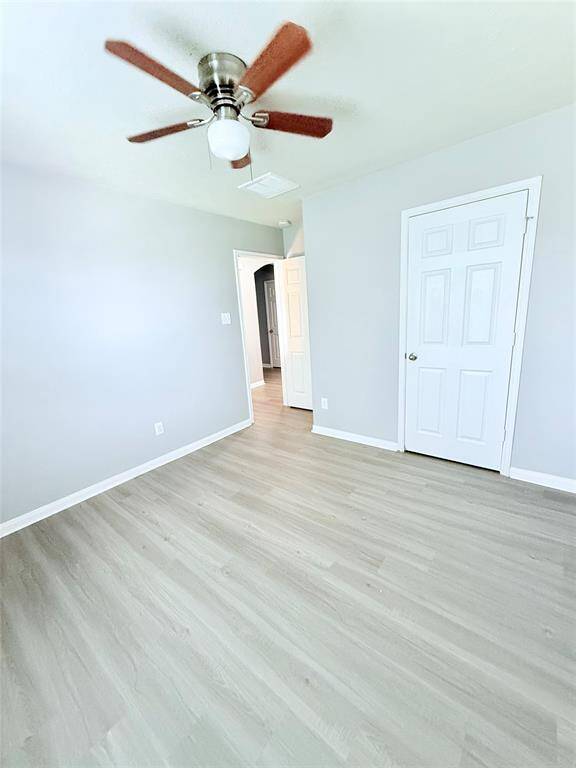 Charming third bedroom featuring sleek flooring and a modern ceiling fan, perfect for a cozy retreat or versatile home office.