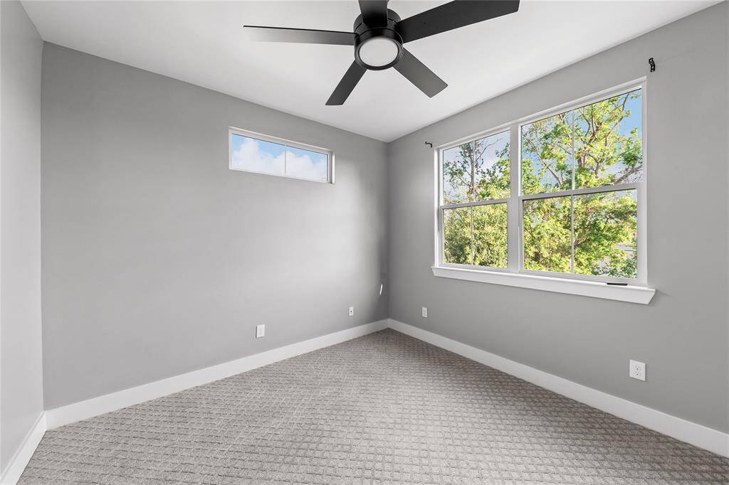 Large windows fill each secondary bedroom with natural light, creating a warm and welcoming atmosphere.