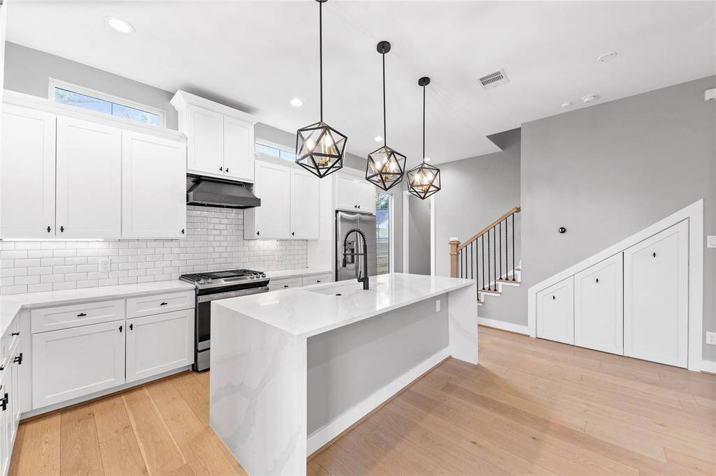 The oversized quartz waterfall island seamlessly connects the kitchen to the living area, creating the perfect space for entertaining.