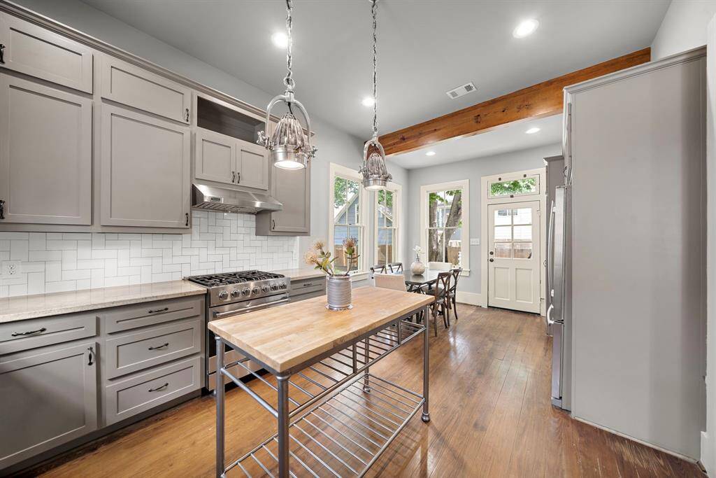 VIKING 5-burner gas range with matching vent hood. ALL kitchen appliances and washer / dryer convey with home. Dining area in the far corner of this space