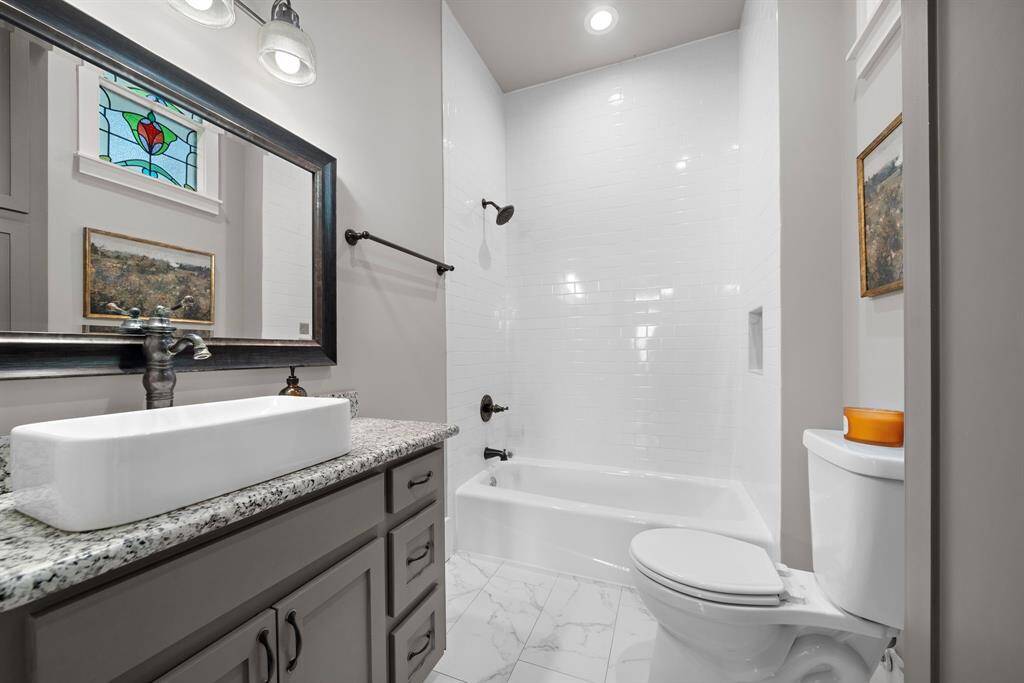 Bathroom - note the stained glass window letting in natural light but maintaining privacy! Large linen / storage closet tucked away in the corner - plenty of storage!