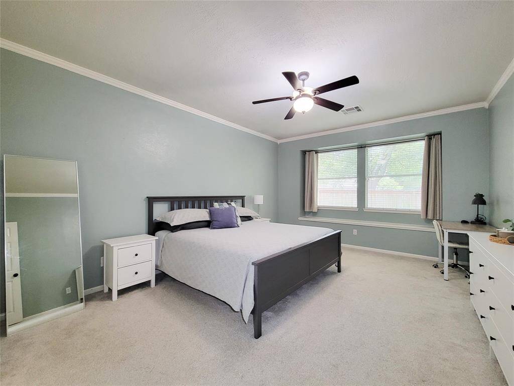 Large Primary Bedroom with crown molding & cozy window seat.