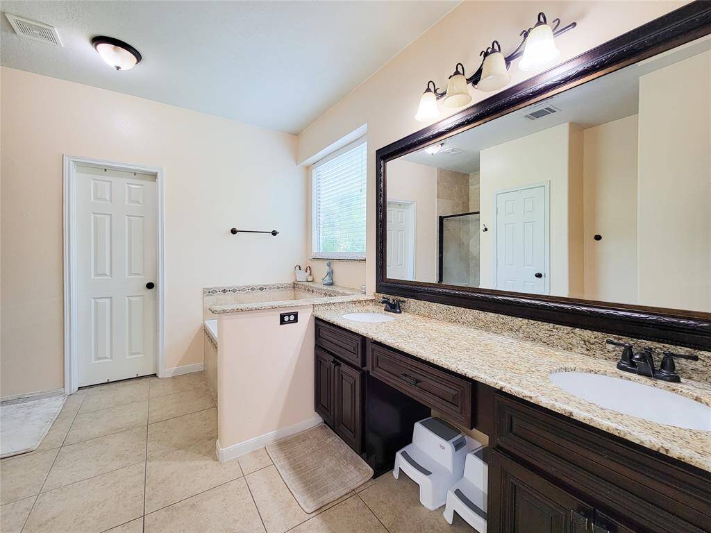 Primary Bathroom with updated granite counters, light fixtures, nickel finish faucets, designer tile boarder & more.