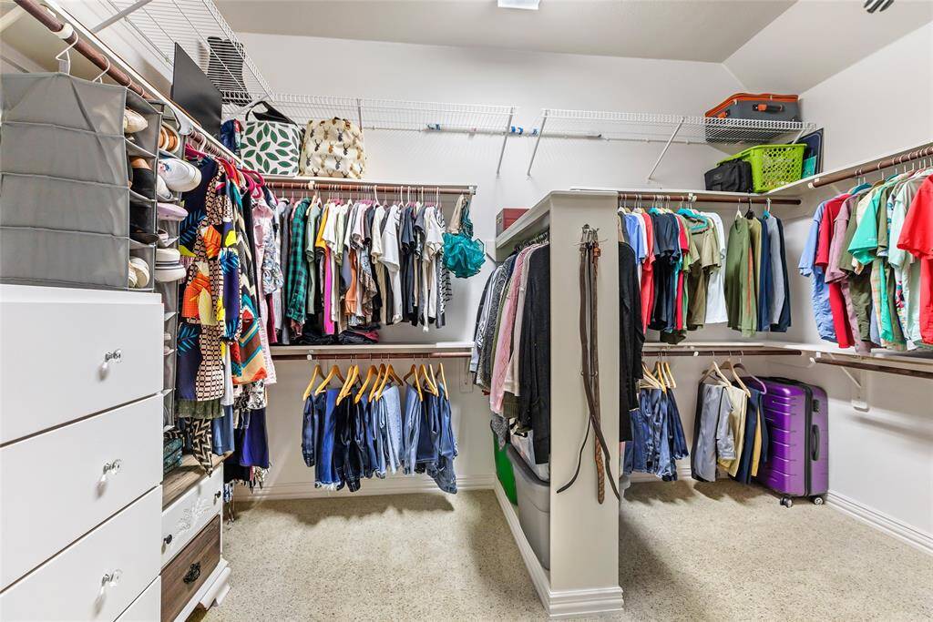 Primary closet with built in drawers and shelves.