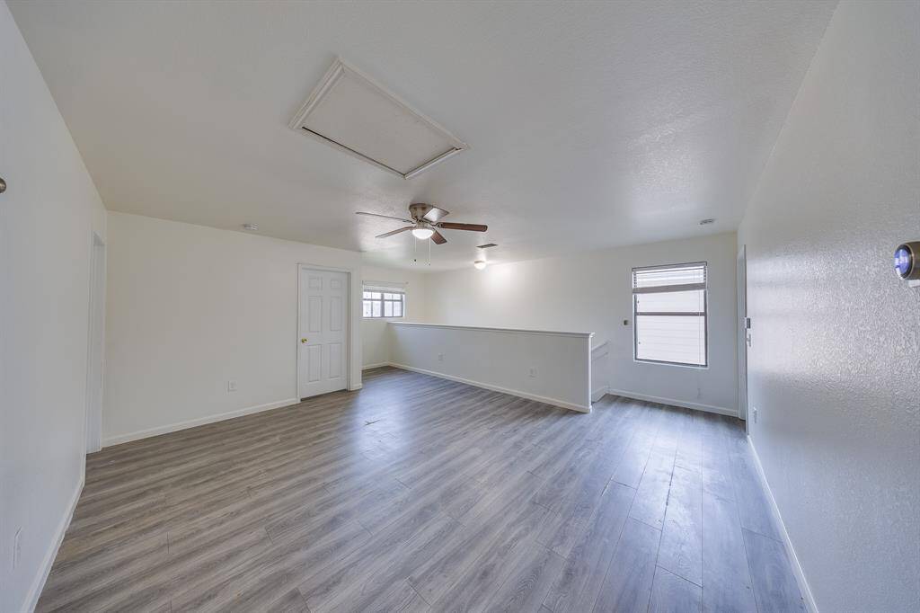 Warm light streams through windows, brightening the game room and stairs with a cozy, inviting glow.
