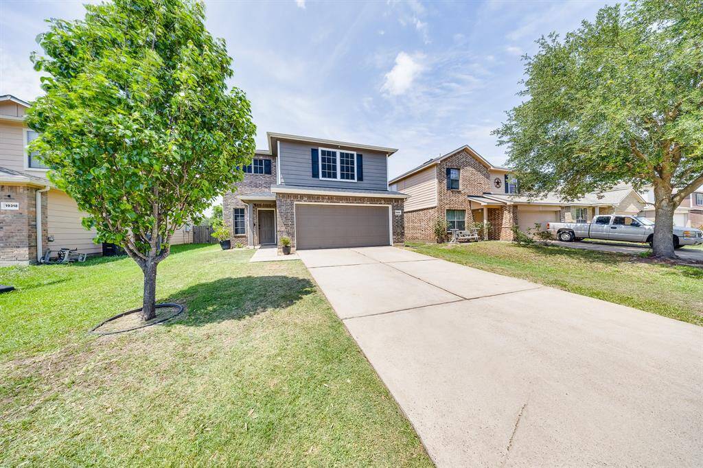 Front yard features a beautiful mature tree, adding natural charm and shade to the landscaped entrance.