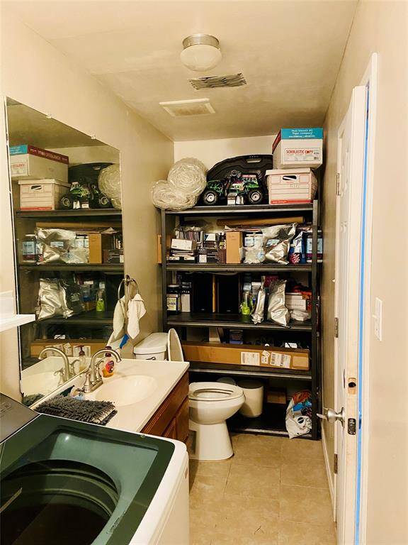 Laundry room has a convenient half bath and room for storage