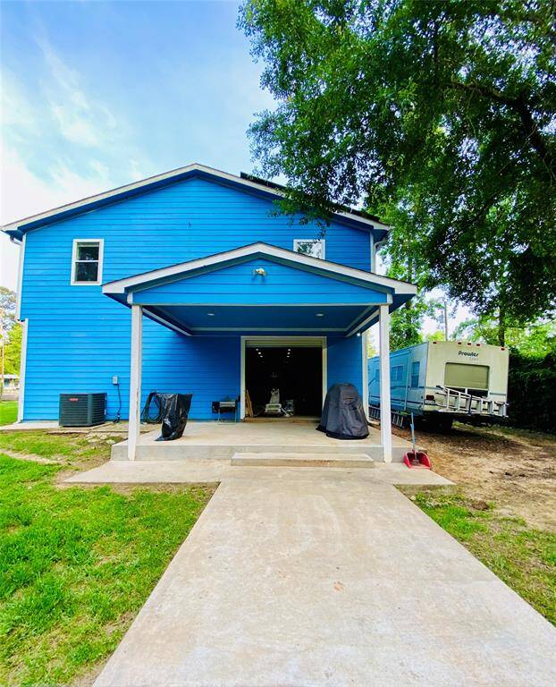 View of back yard covered deck and RV parking on the side.