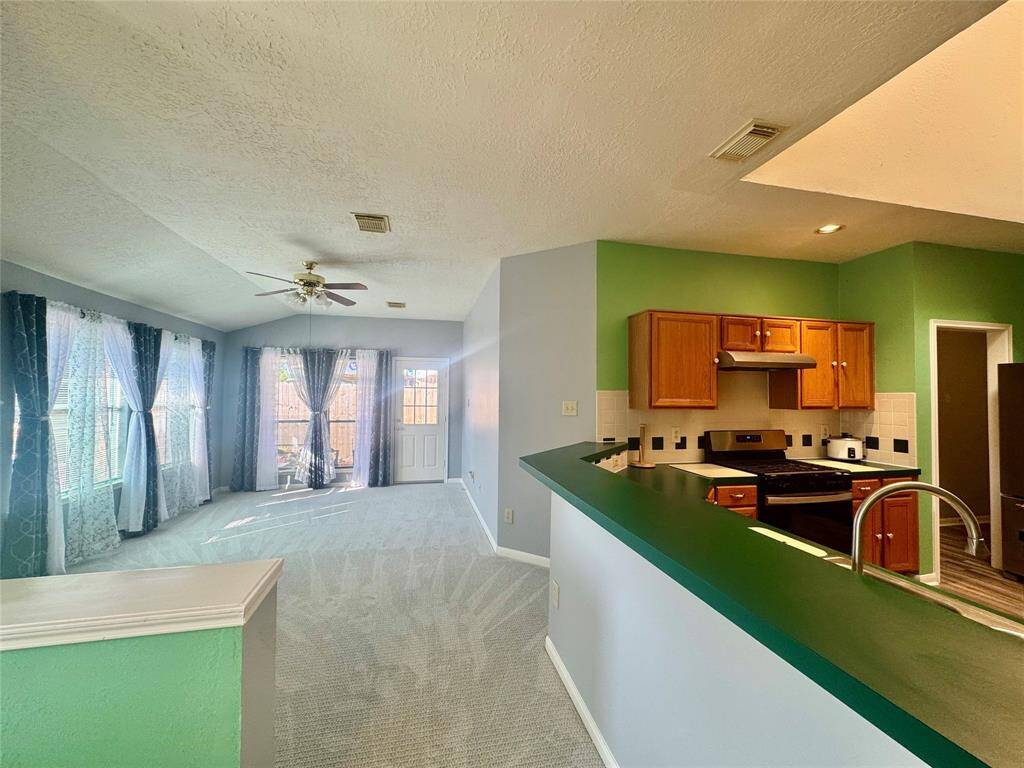 Kitchen bar overlooks breakfast and family room. Notice side door to backyard covered patio.