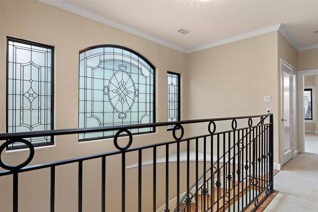 Elegant spiral staircase featuring wrought-iron railings and rich oak steps.