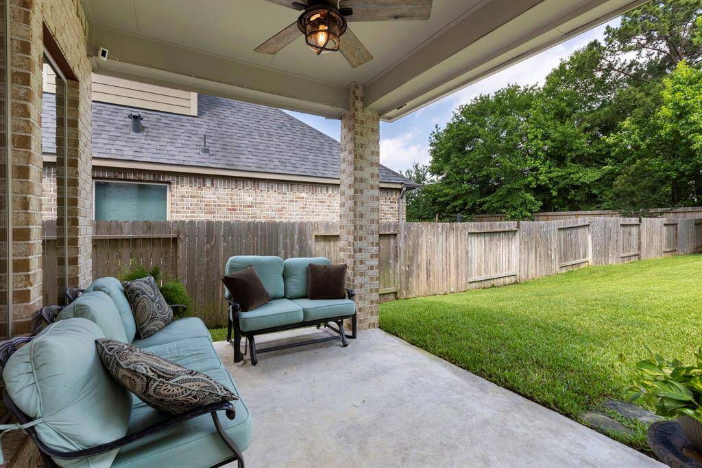 The covered back patio includes a ceiling fan and offers ample space for both outdoor kitchen and patio furniture.