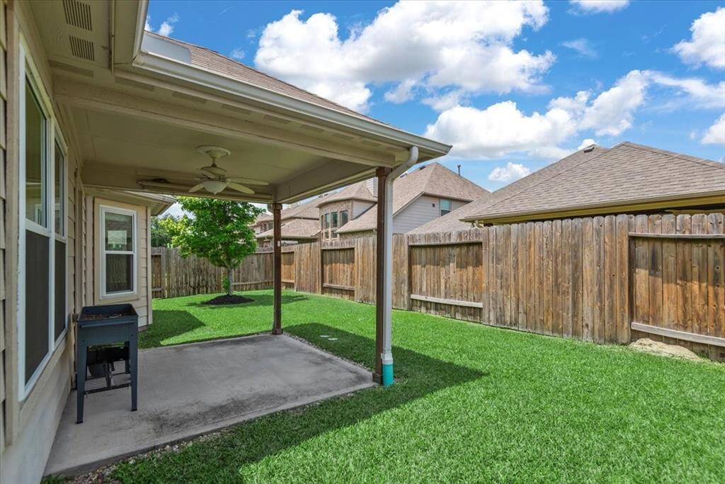 The covered patio provides a shaded outdoor entertainment space.