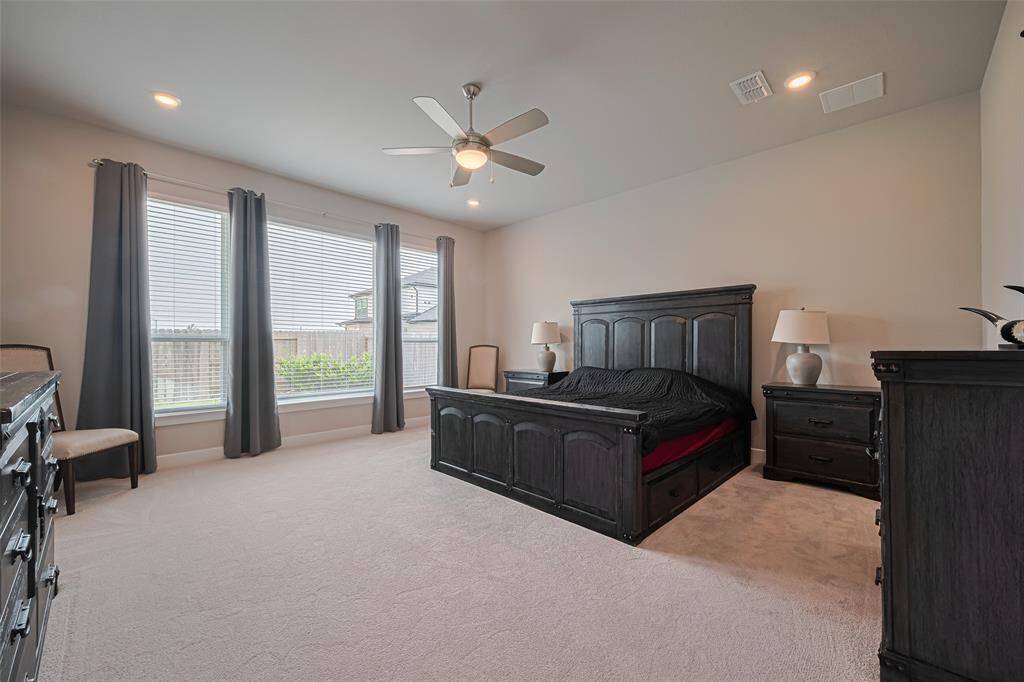 Primary bedroom is extended and private with large windows for natural light & ceiling fan.