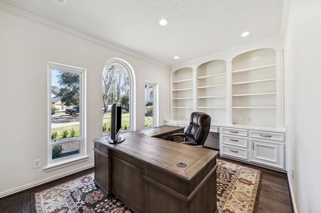 This stunning home office offers warm wood floors, lots of shelves and cabinets for storage.  It is tucked away near the Primary for a quiet experience.