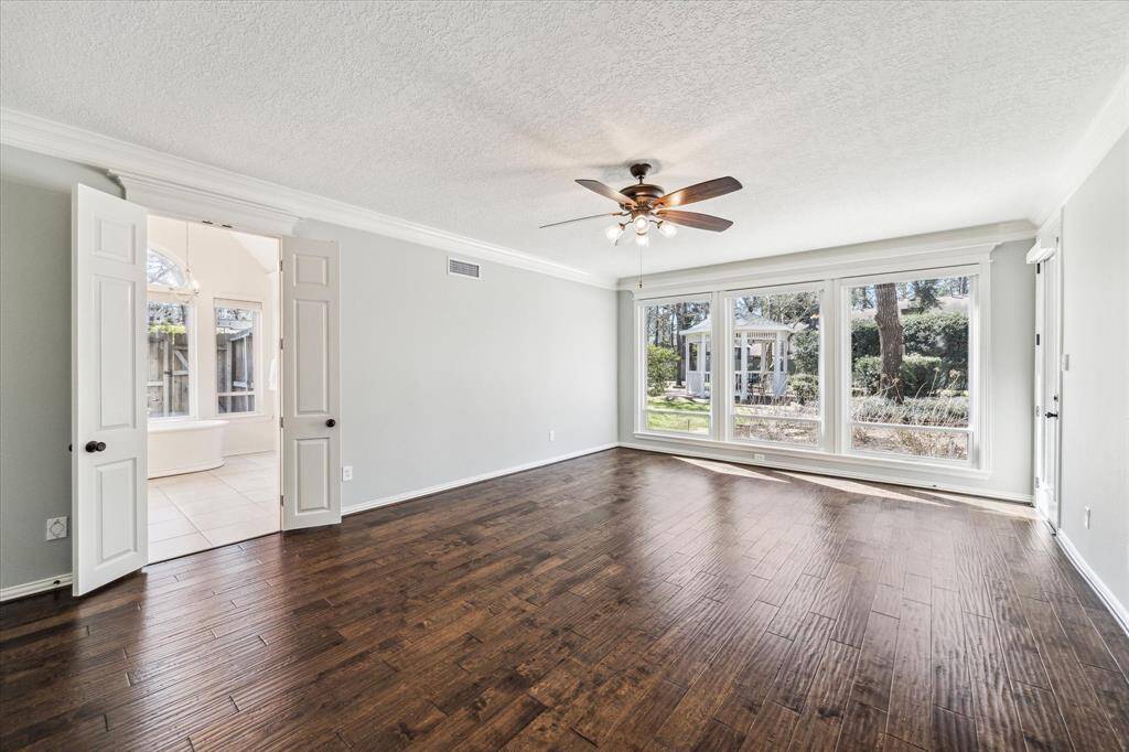 The Primary suite is filled with light from the the wall of windows.  There is a door to go out to one of the private patios. This expansive room can host a multitude of furniture including a sitting area.