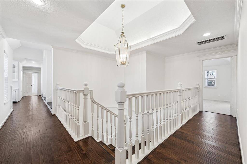 The beautiful wood flooring expands up the stairs and down the hallways.  Look at the architectural ceiling above the stairs.