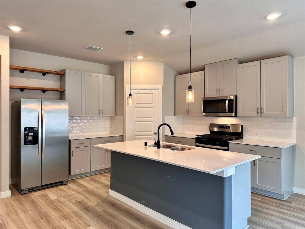 Kitchen with upgraded lighting and large cabinets.