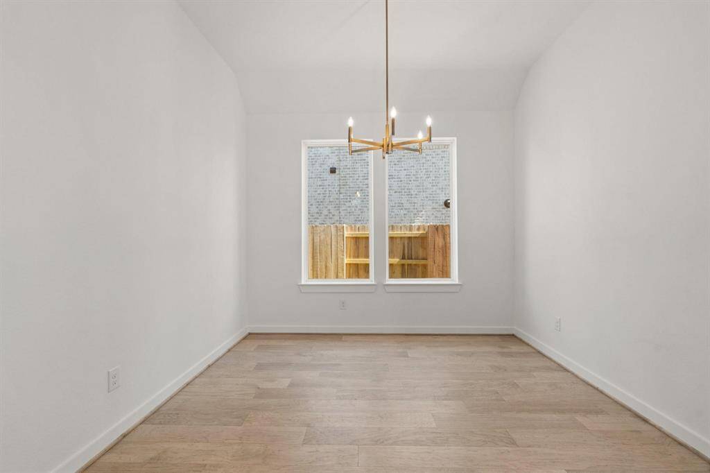 Spacious dining room with designer lamp and hardwood floors