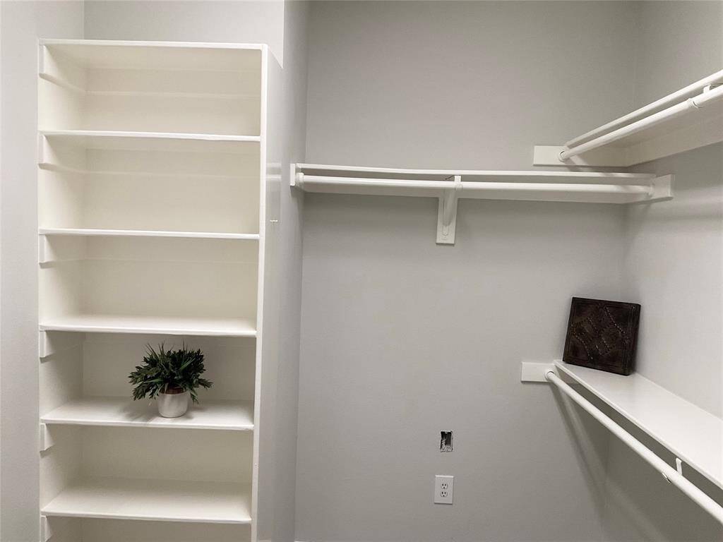 One side of the spacious walk in walk-in closet with built-in shelves and hanging rods, ideal for organized storage.  It is bright and will be easy to organize efficiently,