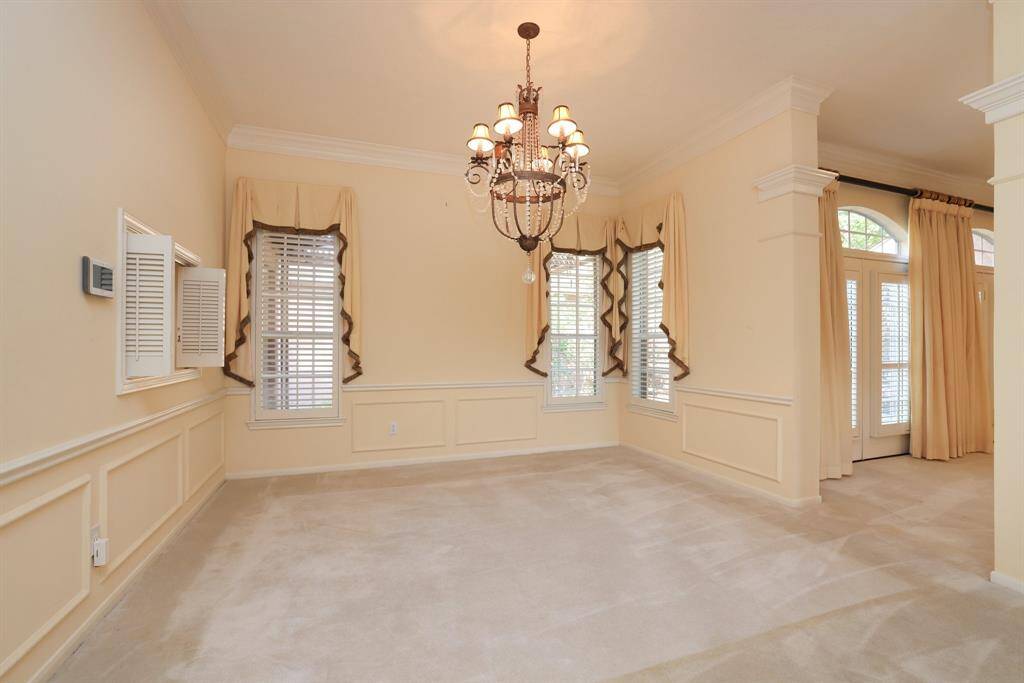Custom drapery throughout, complemented by select shutters, enhances the home’s charm. You’ll appreciate the abundance of natural light, high ceilings, and ample storage options.