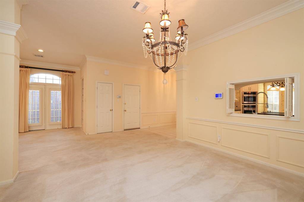 Ideal for both casual gatherings and formal dinners, this spacious area can accommodate large-scale furniture effortlessly. Take note of the crown molding and the seamless flow of the open-concept design in this single-story layout.