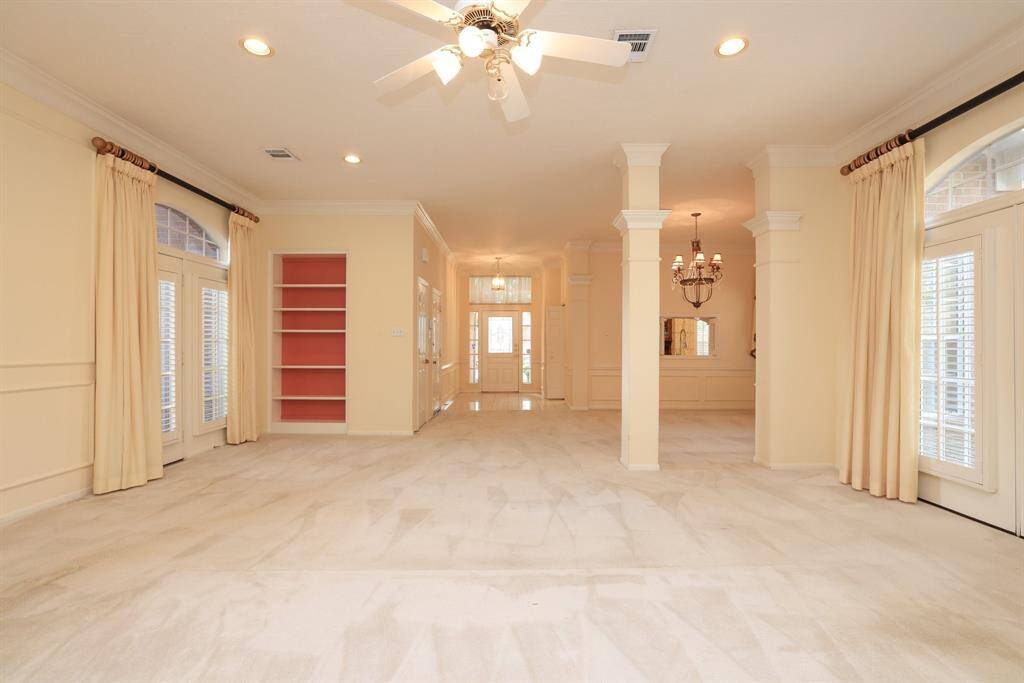Looking back toward the front of the home,formal dining is to the right, with the kitchen just beyond near the front foyer. To the left, you’ll find access to the garage and the peaceful atrium space.
