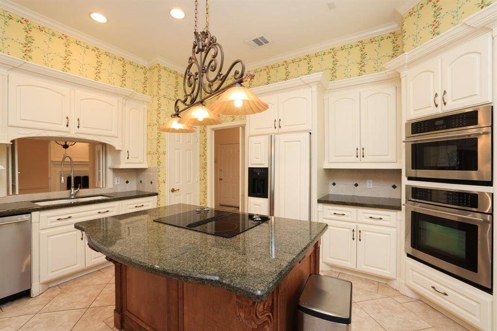 A serving bar opens to your formal dining space, ideal for entertaining. The kitchen offers ample cabinet space and additional pantry storage conveniently located in the indoor utility room.