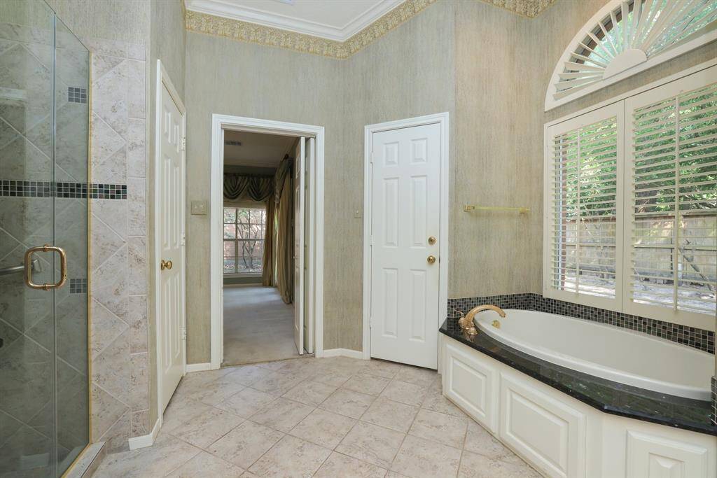 Step into the oversized walk-in shower adorned with intricate tile design, promising a luxurious bathing experience. As you enter, you'll discover the water closet, soaking tub and TWO walk in closets.