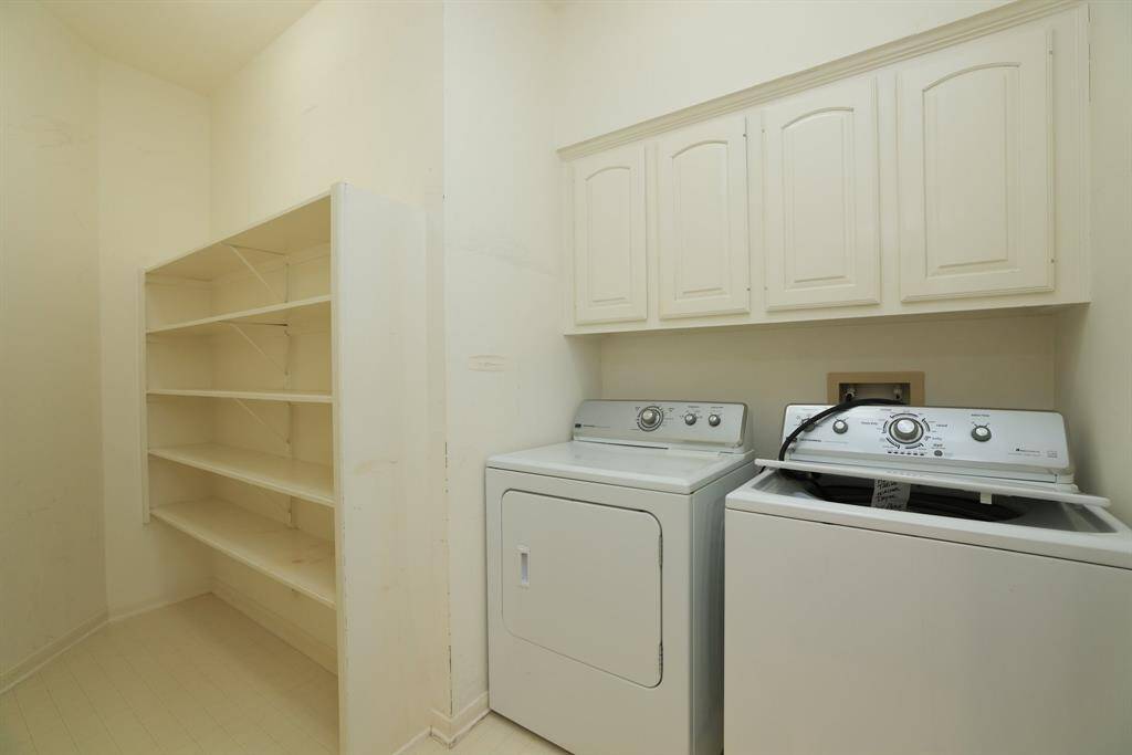 The indoor utility room features washer and dryer connections, upper cabinet storage, and serves as the perfect space for a secondary pantry or additional household organization.