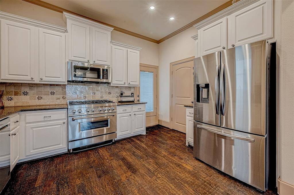 This spacious kitchen features stainless steel appliances, including a 5-burner Zline gas cooktop