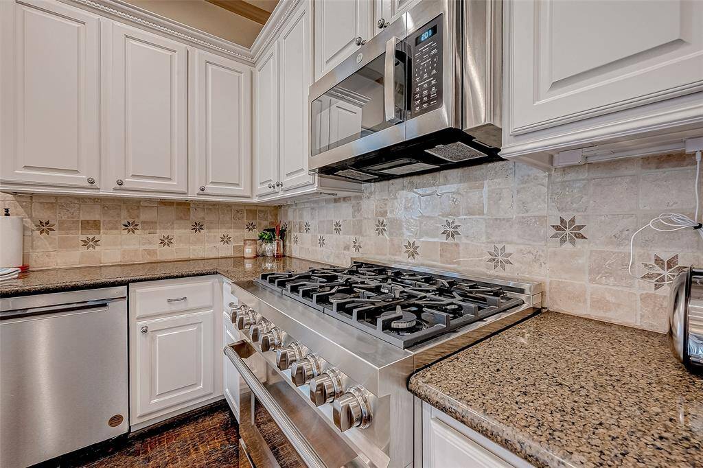 This kitchen is equipped with updated stainless steel appliances, including a 5-burner Zline gas cooktop and oven, perfect for cooking and entertaining.