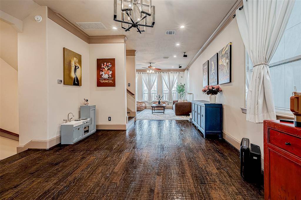 The second-floor living space features hardwood floors, soundproof windows, a modern chandelier, and a cozy seating area.