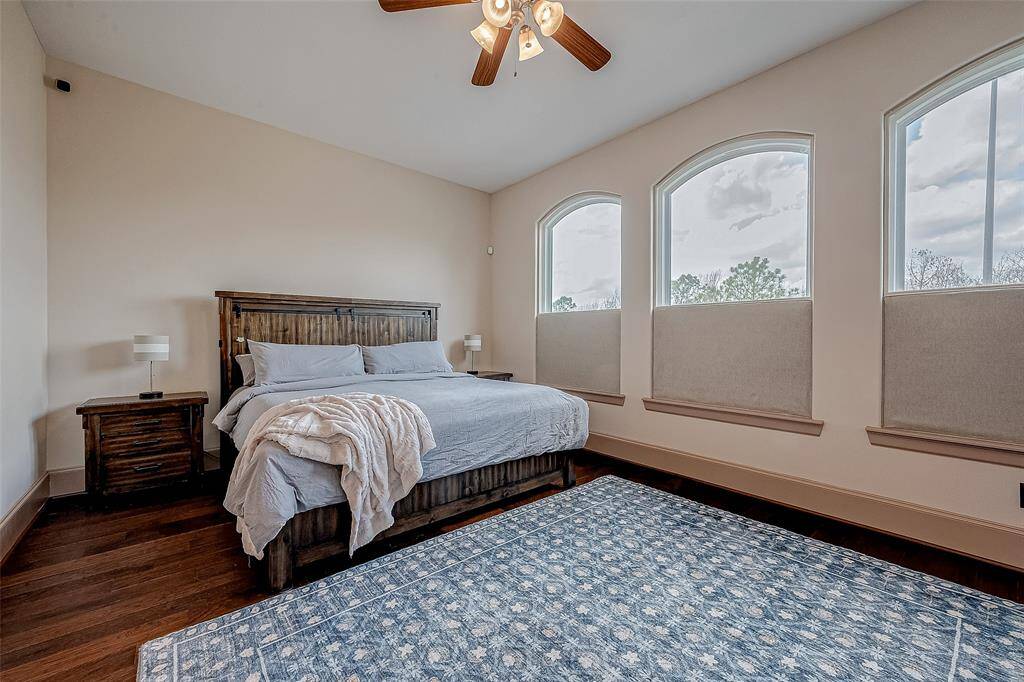 This bright and cozy primary bedroom features natural light through three arched, soundproof windows with downtown views.