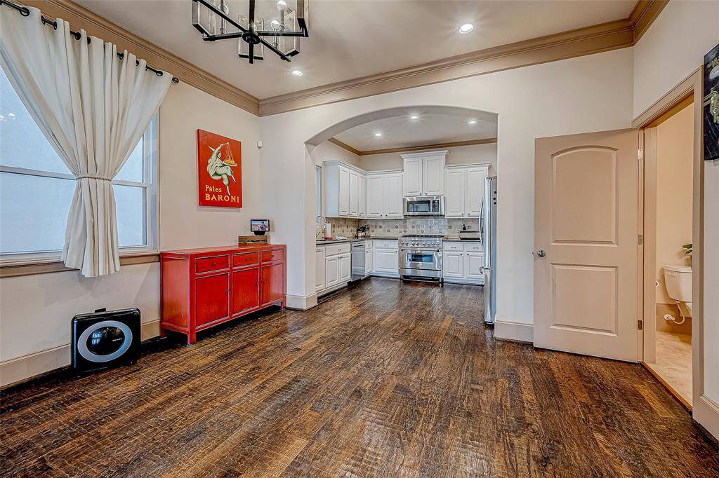 Spacious kitchen and dining area with elegant wood flooring and soft recessed lighting.