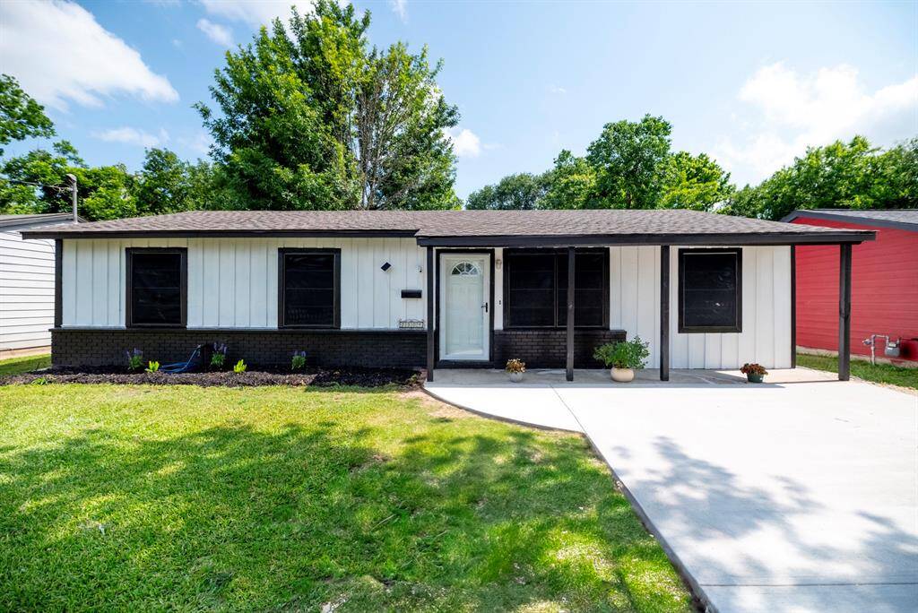 Charming single-story home with a modern black-and-white exterior. Features a covered entrance, fresh landscaping, and a spacious driveway. Surrounded by greenery, offering a cozy and inviting atmosphere.