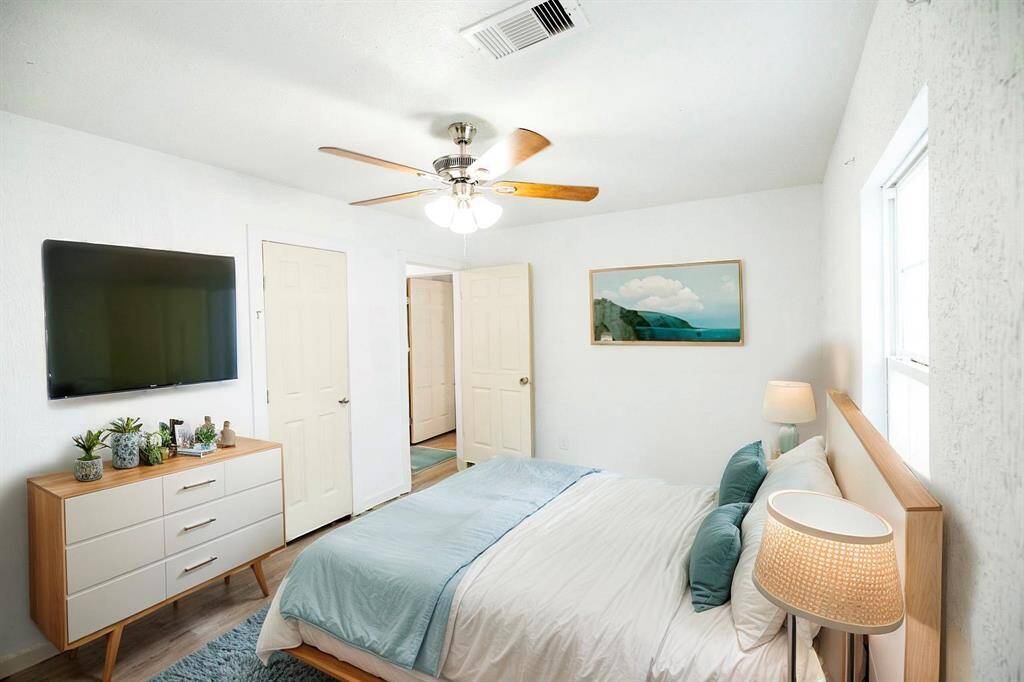This bright, cozy Primary bedroom features a large window, modern ceiling fan, offering a relaxing and functional space. Virtually staged.