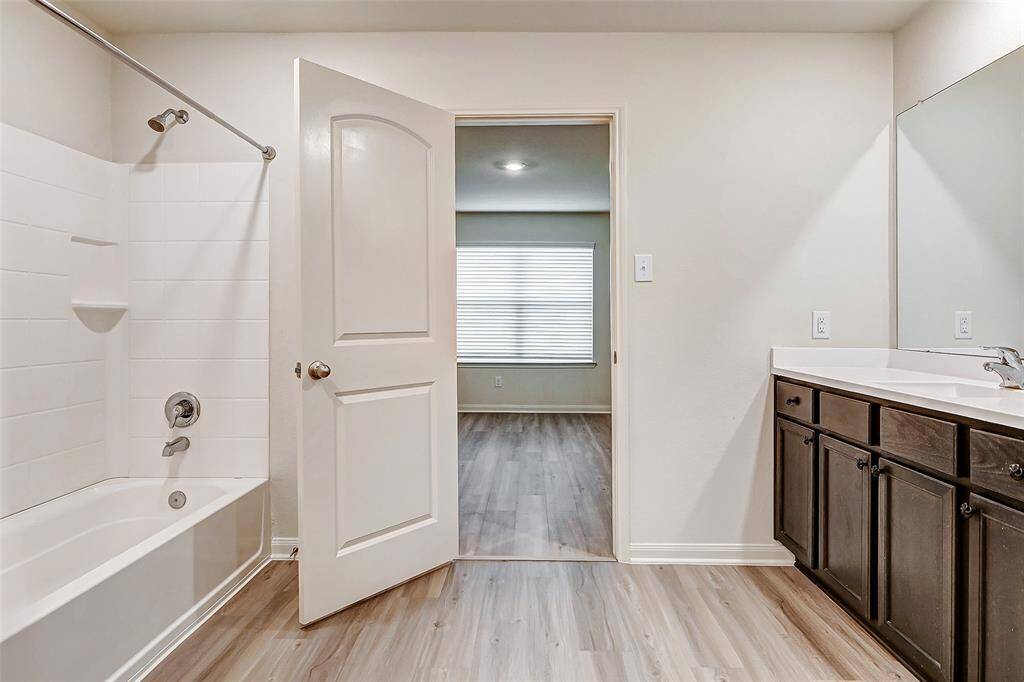 Fully tiled shower/tub in primary bath.
